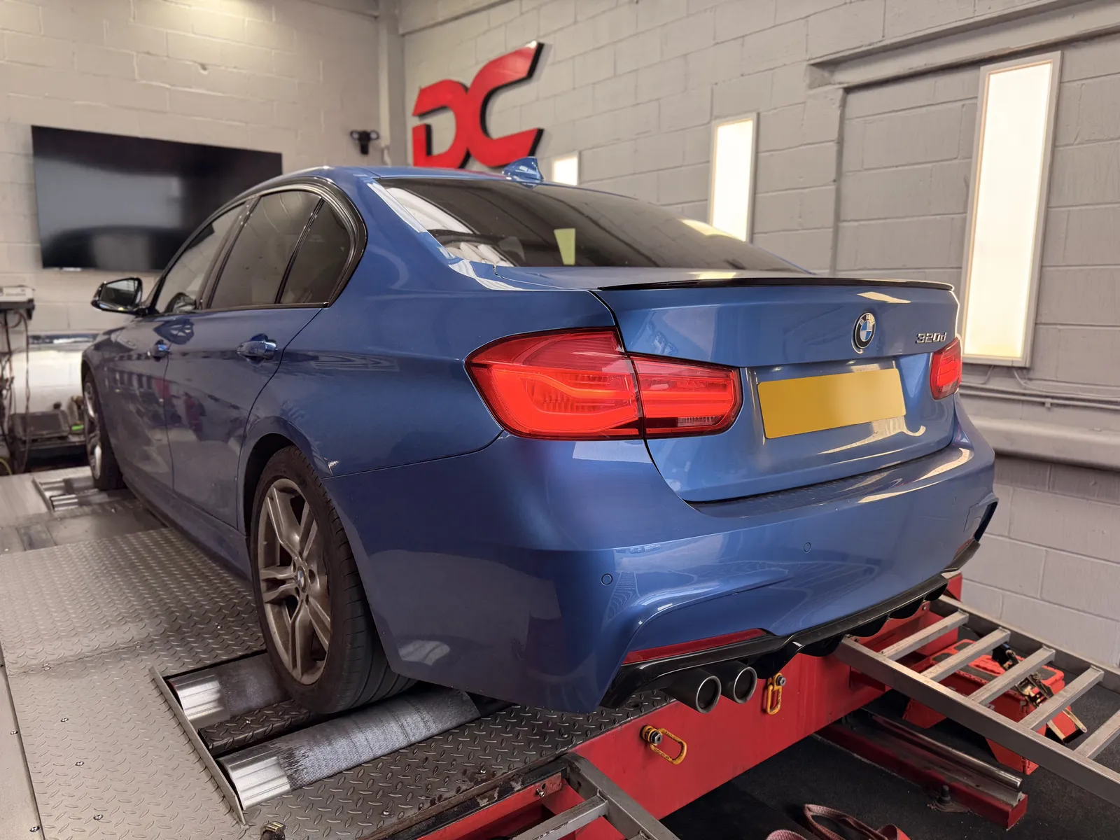 BMW 320d rear three-quarter on the dyno under the DC sign