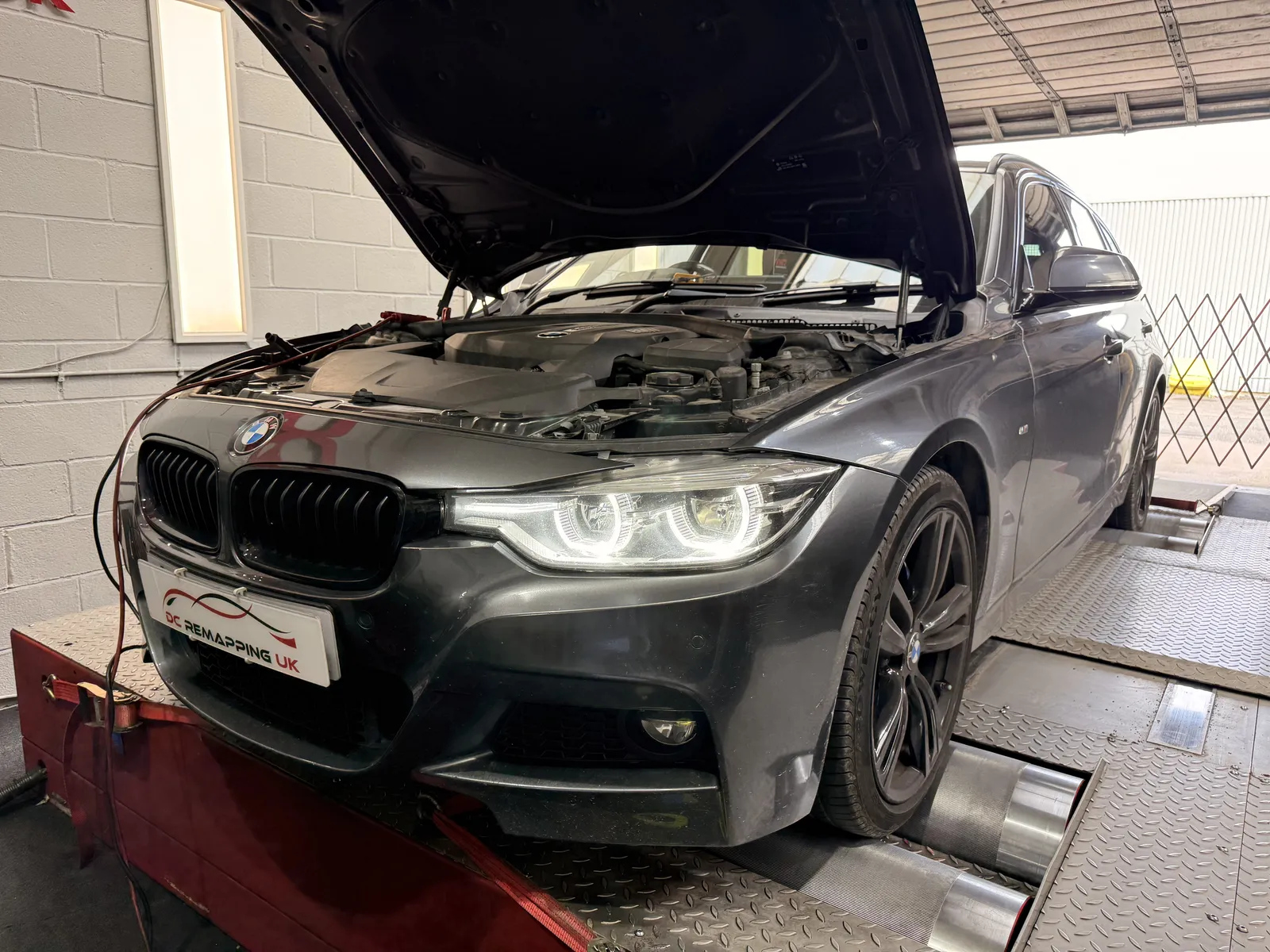 BMW 320i xDrive Touring front three-quarter with the bonnet up