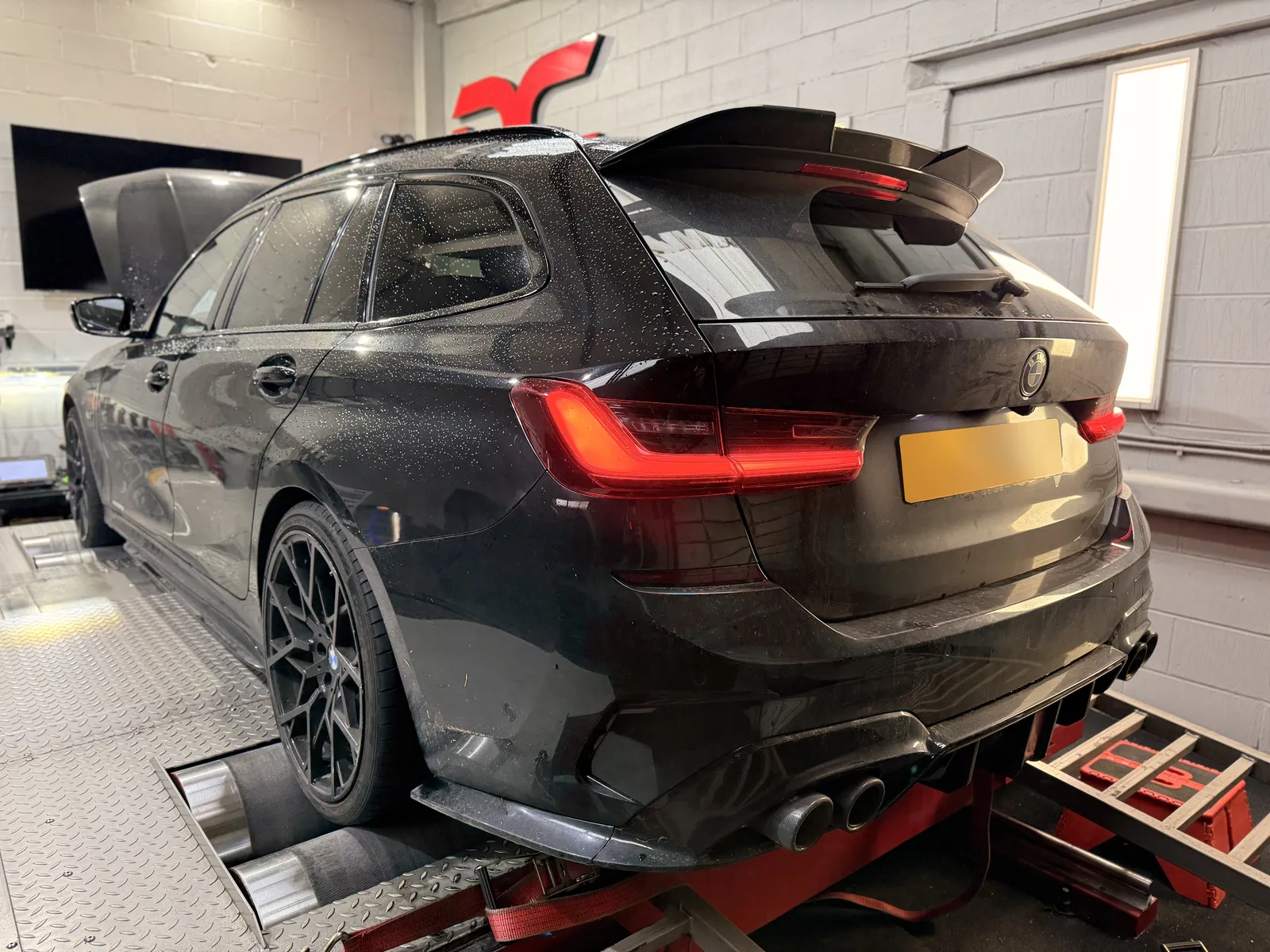 BMW 330e Touring rear three-quarter on the dyno under the DC sign