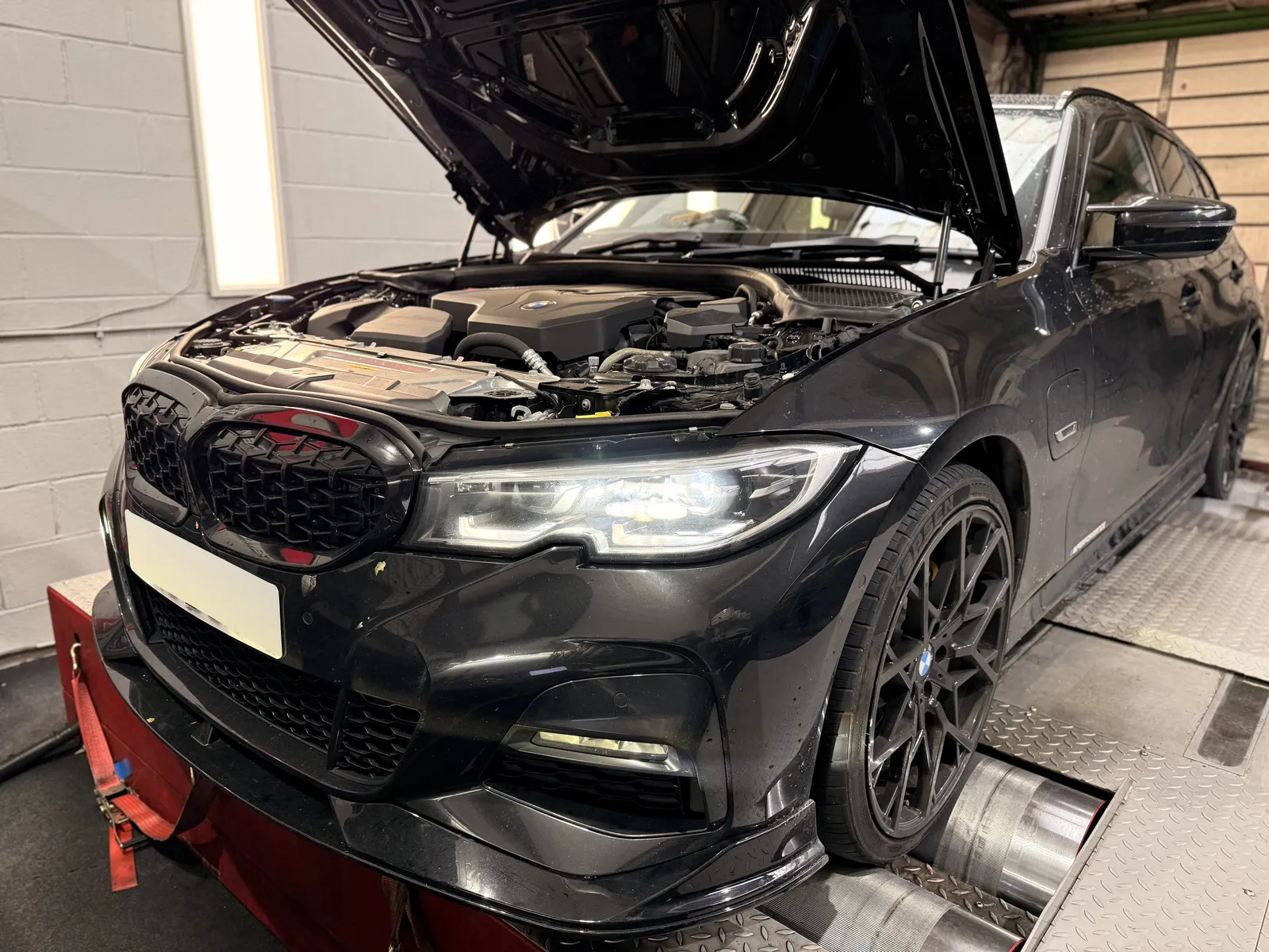 BMW 330e Touring front three-quarter on the dyno with the bonnet up