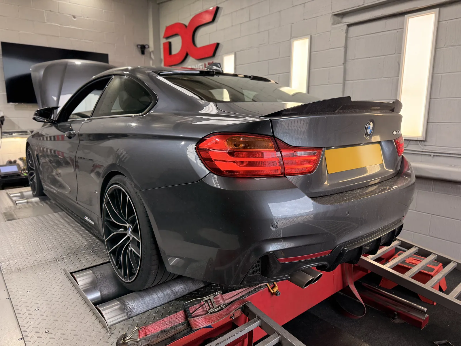 BMW 420d Coupé rear three-quarter on the dyno under the DC sign