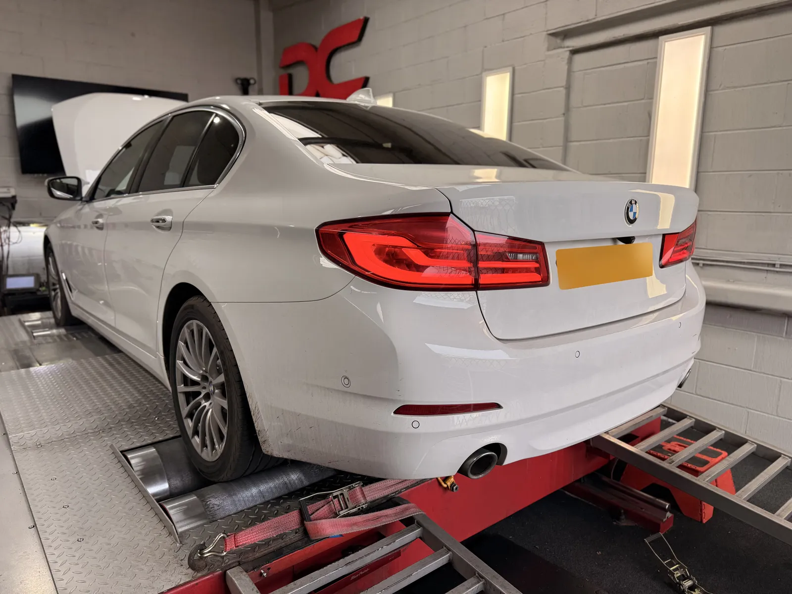 BMW 520d rear three-quarter on the dyno under the DC sign