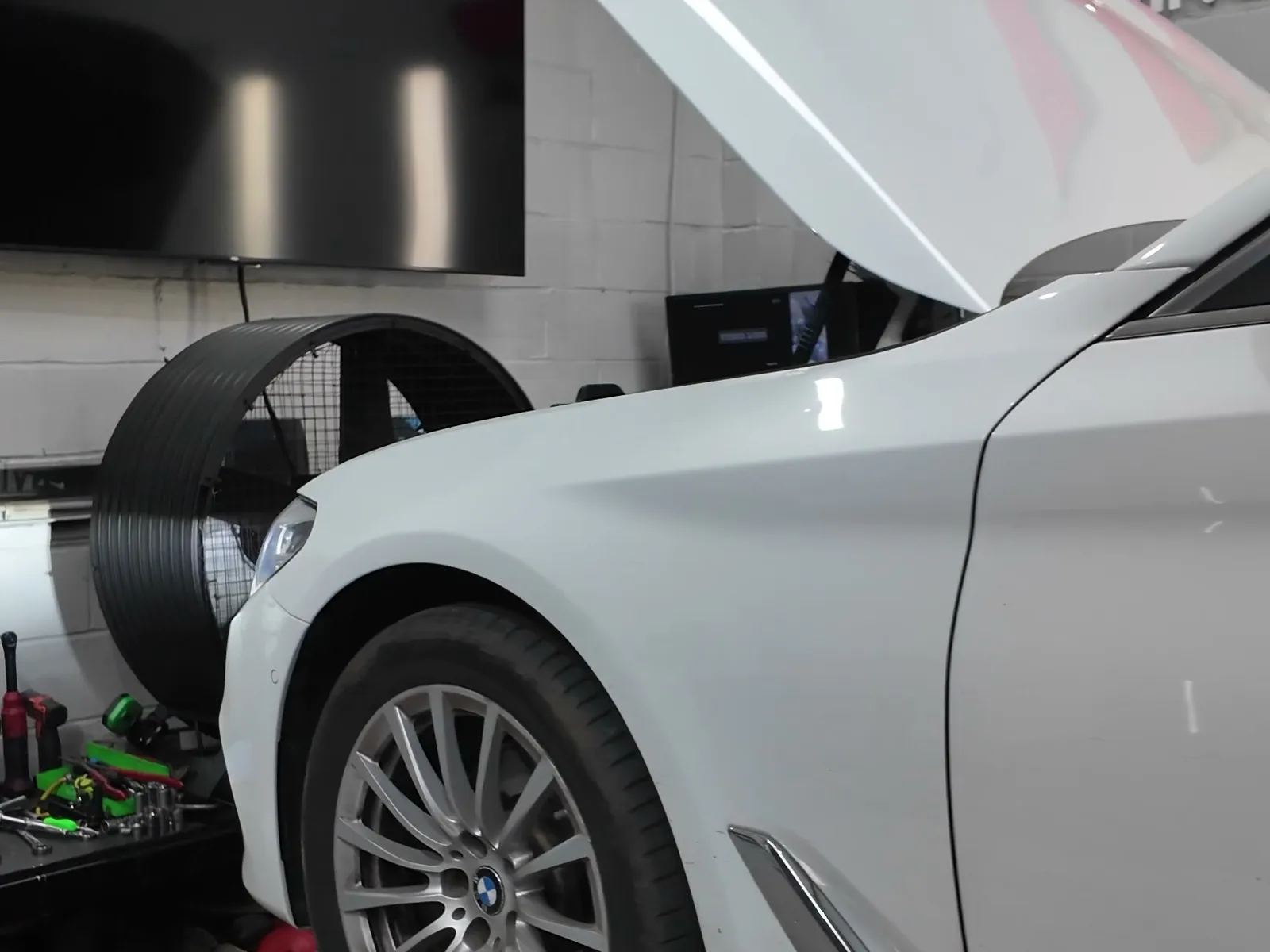 BMW 520d front wheel on the rollers, bonnet up