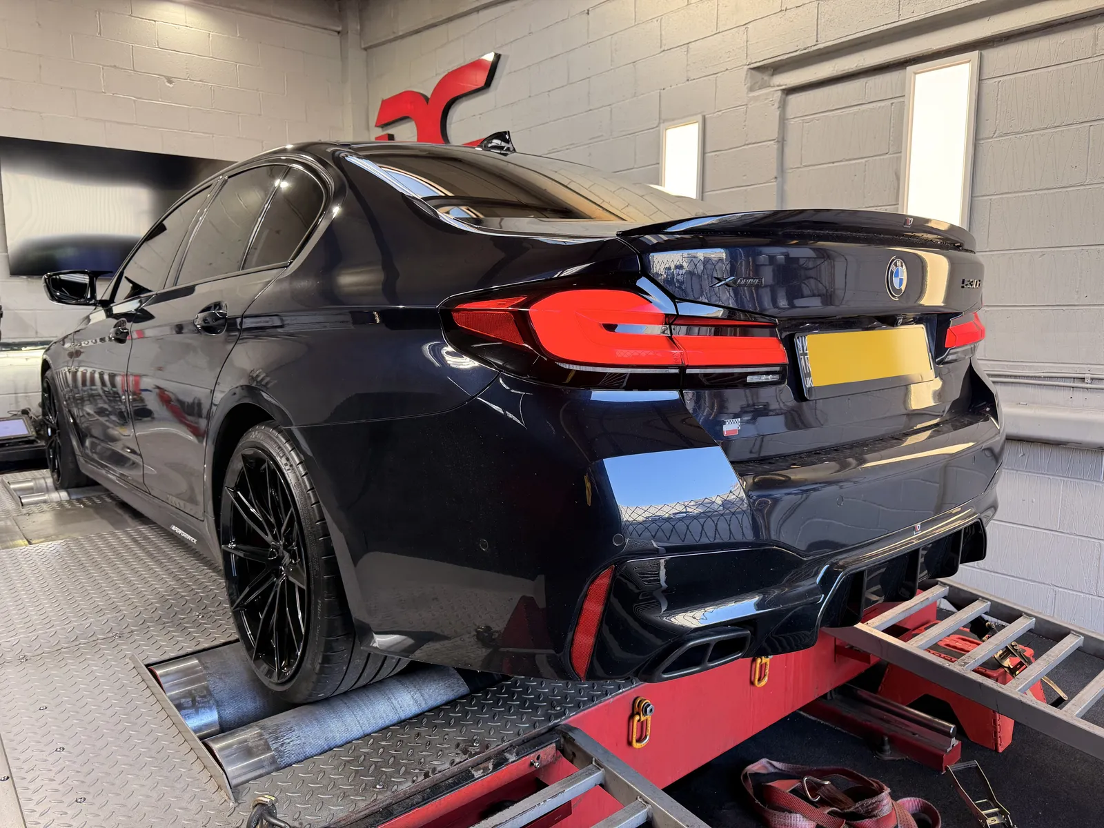 BMW 530d xDrive rear three-quarter on the dyno under the DC sign