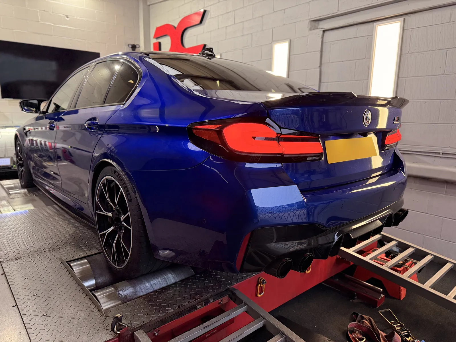 BMW M5 Competition rear three-quarter on the dyno under the DC sign
