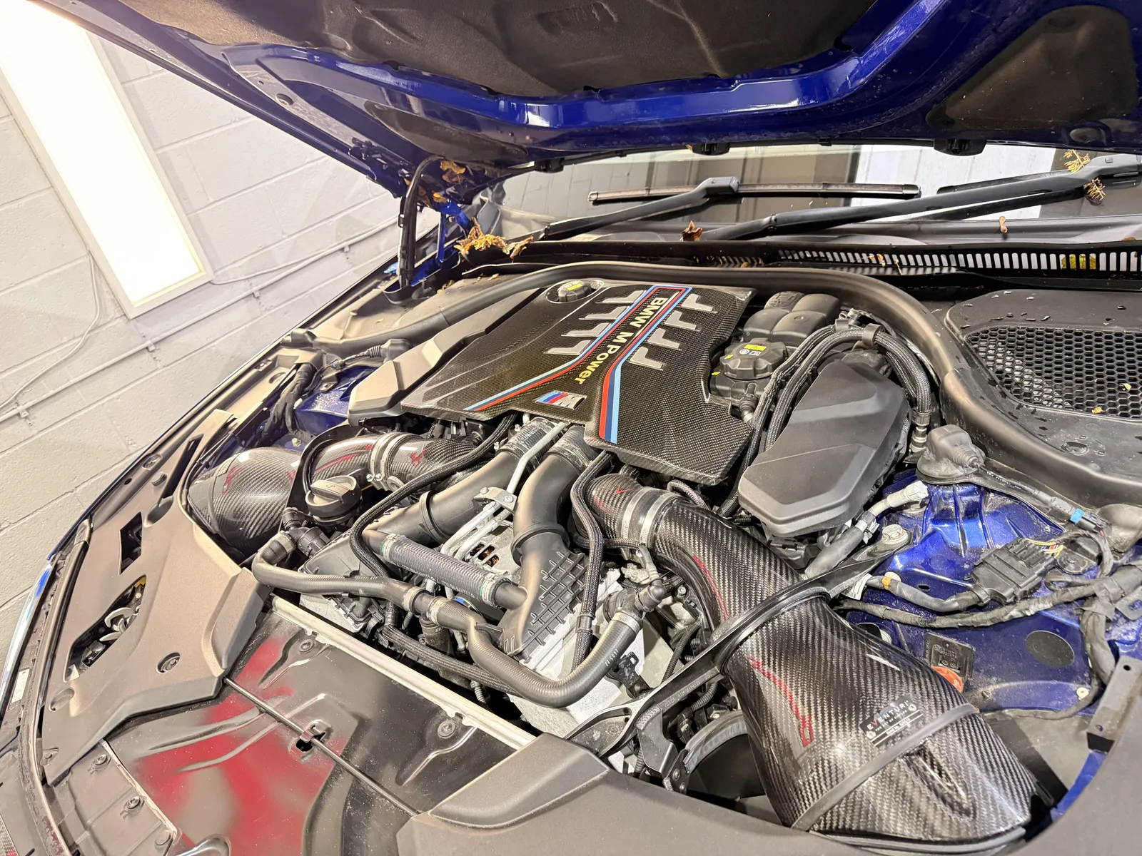BMW M5 Competition S63 4.4 twin-turbo V8 engine bay with carbon intakes