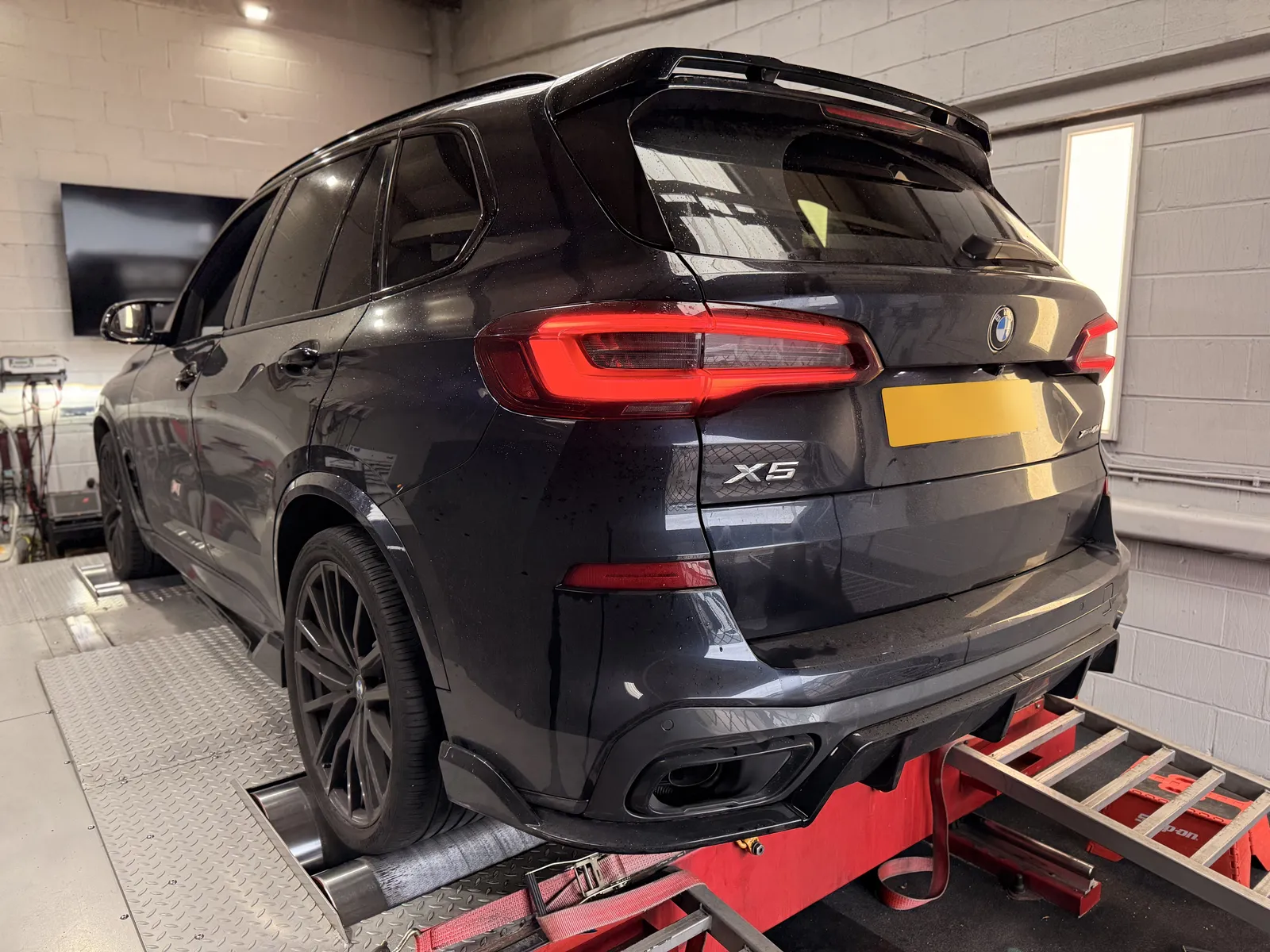 BMW X5 40d rear three-quarter on the dyno under the DC sign