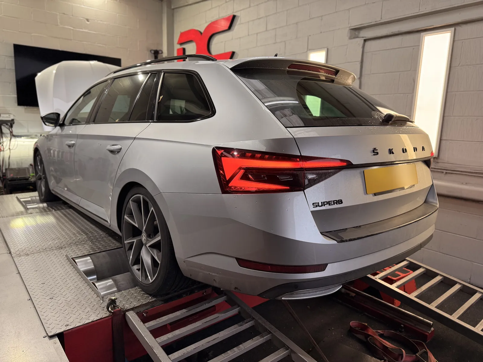 Skoda Superb rear three-quarter on the dyno under the DC sign